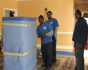 Movers in living room with padded furniture